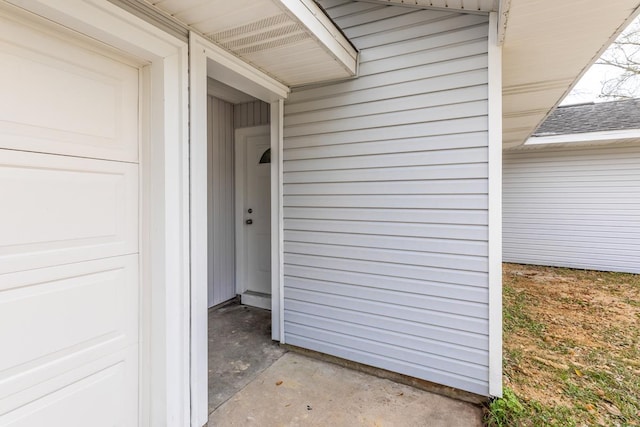 property entrance with a garage and roof with shingles