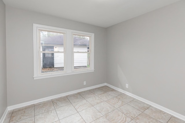 empty room featuring light tile patterned floors and baseboards