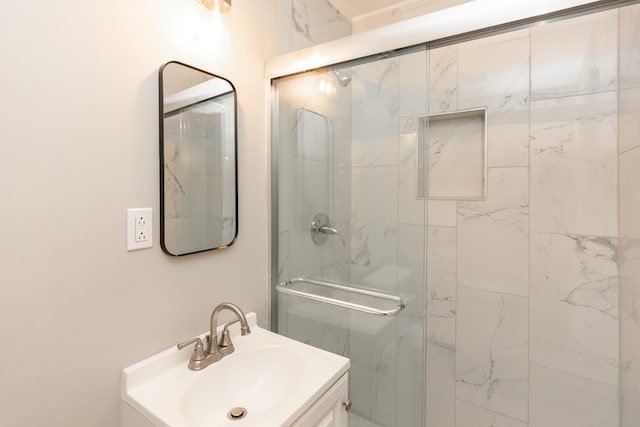 full bath featuring a marble finish shower and a sink