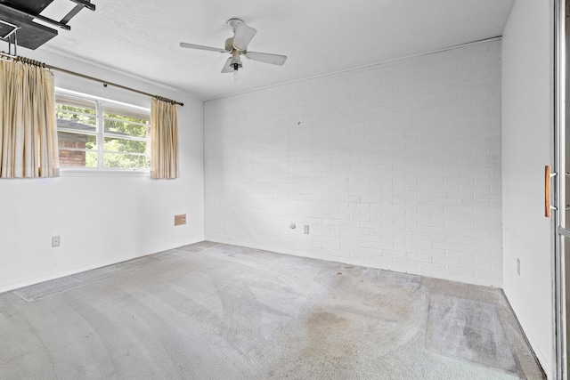 470 Junker Rd, Beaumont, TX 77707 - spare room featuring brick wall, a ceiling fan, carpet flooring, baseboards, and a textured ceiling
