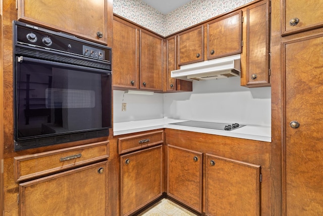 470 Junker Rd, Beaumont, TX 77707 - kitchen featuring under cabinet range hood, black appliances, brown cabinetry, and light countertops