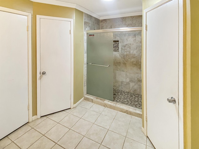 bathroom featuring crown molding, a shower with door, and tile patterned floors