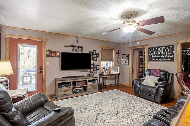 living room with hardwood / wood-style floors, a textured ceiling, ceiling fan, and ornamental molding