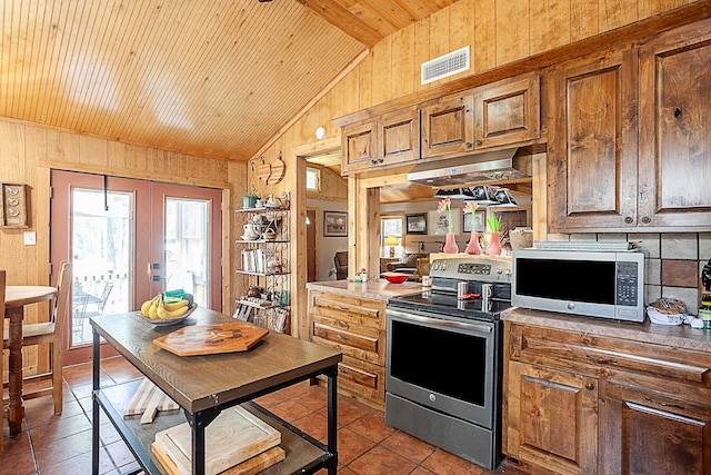 kitchen featuring lofted ceiling, french doors, wooden walls, wood ceiling, and stainless steel appliances