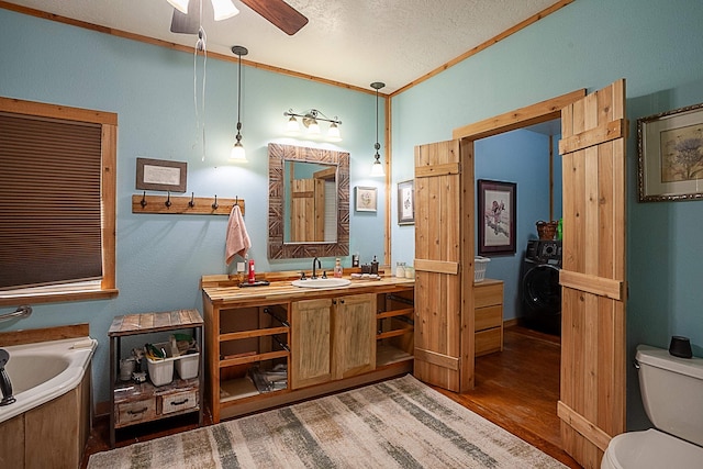 bathroom with vanity, crown molding, hardwood / wood-style flooring, ceiling fan, and toilet