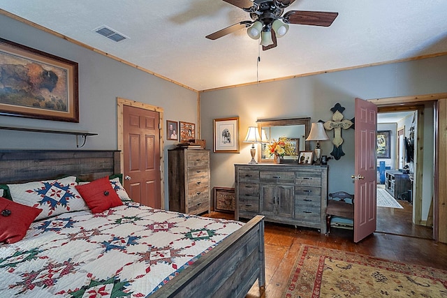 bedroom featuring ceiling fan, dark hardwood / wood-style flooring, a textured ceiling, and ornamental molding