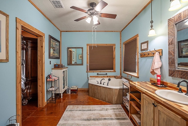 bathroom featuring hardwood / wood-style flooring, ceiling fan, a bathing tub, and crown molding