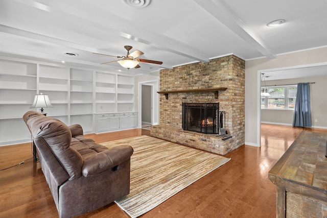 2040 Chevy Chase Ln, Beaumont, TX 77706 - living area with beamed ceiling, ceiling fan, a fireplace, wood finished floors, and baseboards