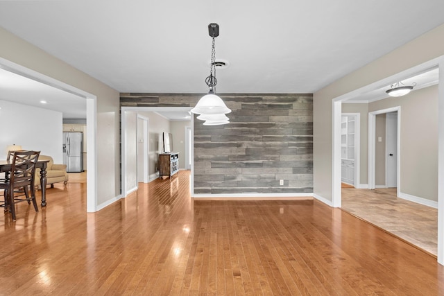 2040 Chevy Chase Ln, Beaumont, TX 77706 - unfurnished dining area featuring an accent wall, light wood finished floors, and baseboards