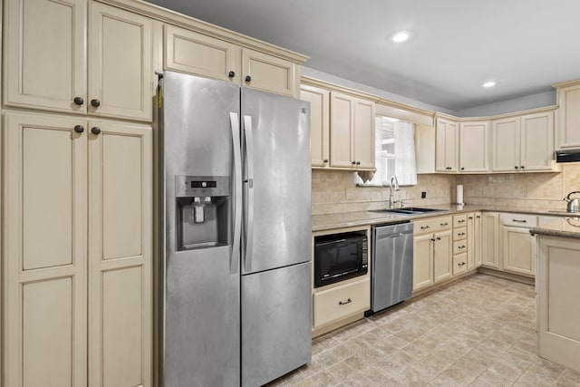 2040 Chevy Chase Ln, Beaumont, TX 77706 - kitchen featuring cream cabinetry, stainless steel appliances, a sink, tasteful backsplash, and light stone countertops