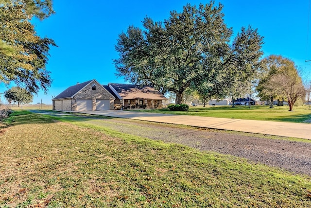 view of yard with concrete driveway and an attached garage