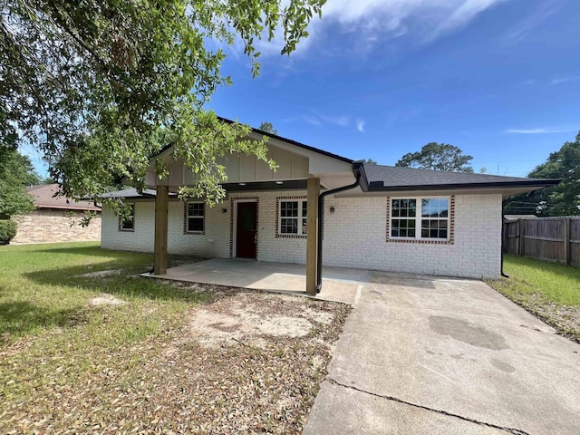 view of front of house with a patio and a front yard