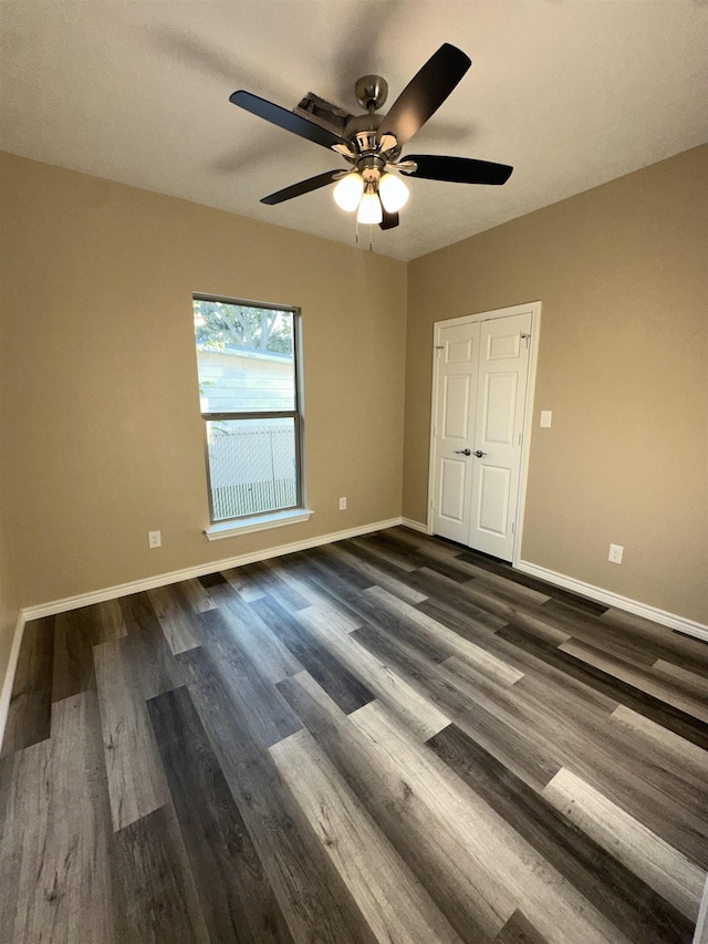 spare room featuring dark hardwood / wood-style floors and ceiling fan