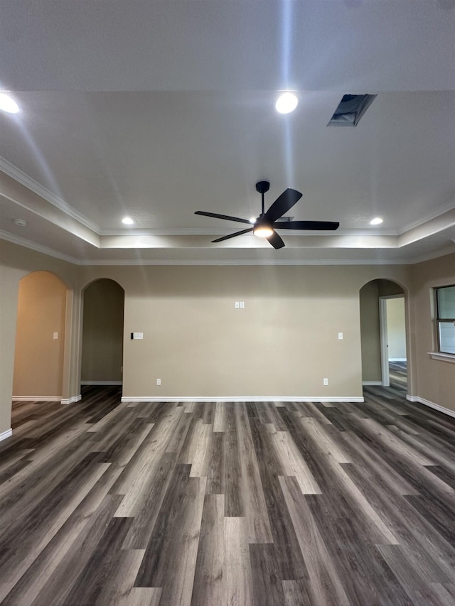 spare room featuring dark hardwood / wood-style flooring, ceiling fan, a raised ceiling, and crown molding