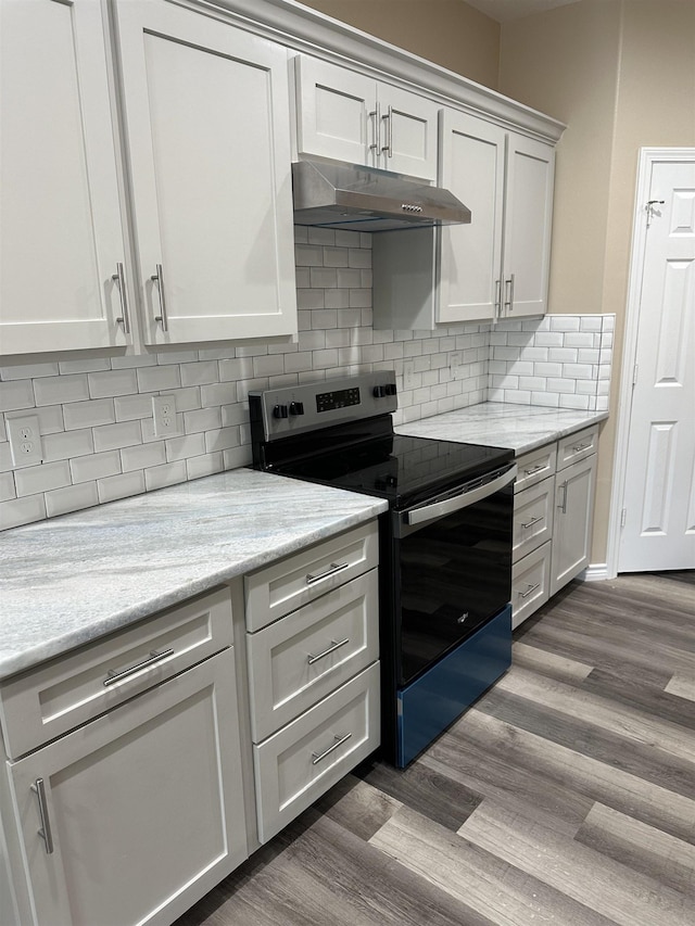 kitchen with dark wood-type flooring, tasteful backsplash, light stone counters, electric stove, and white cabinets