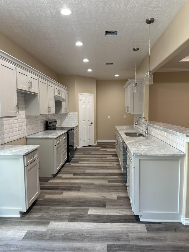 kitchen featuring kitchen peninsula, sink, decorative light fixtures, black electric range, and white cabinetry