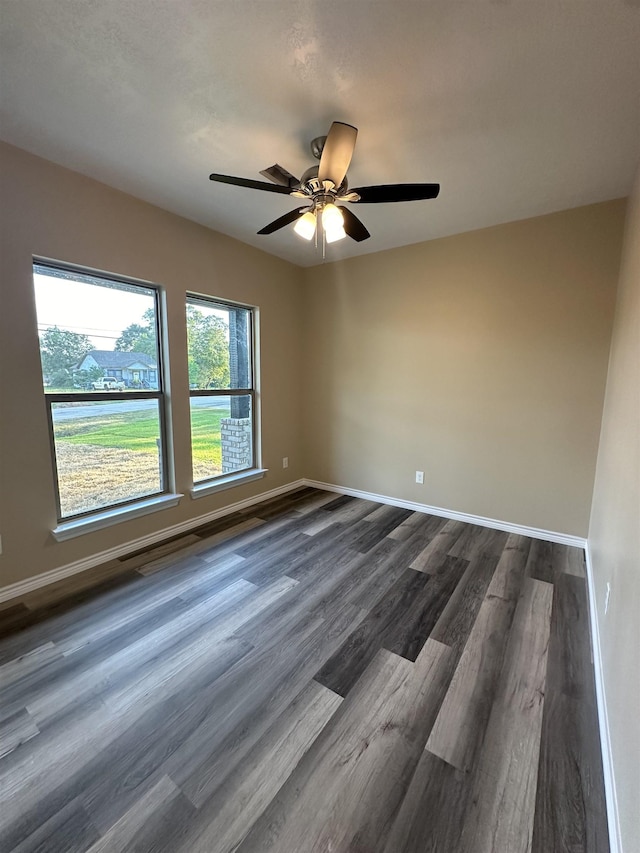 spare room featuring ceiling fan and dark wood-type flooring