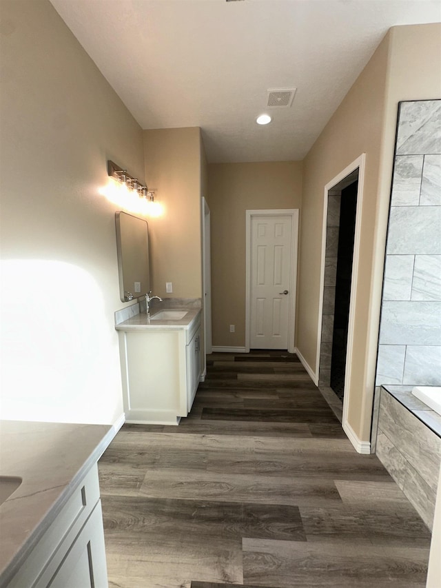 bathroom featuring vanity, hardwood / wood-style flooring, and a bathing tub