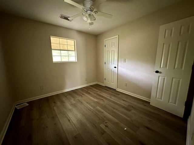 unfurnished bedroom featuring ceiling fan, dark hardwood / wood-style flooring, and a closet