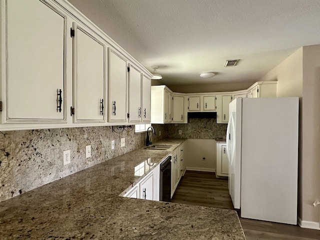 kitchen with sink, white refrigerator, stone countertops, black dishwasher, and white cabinetry