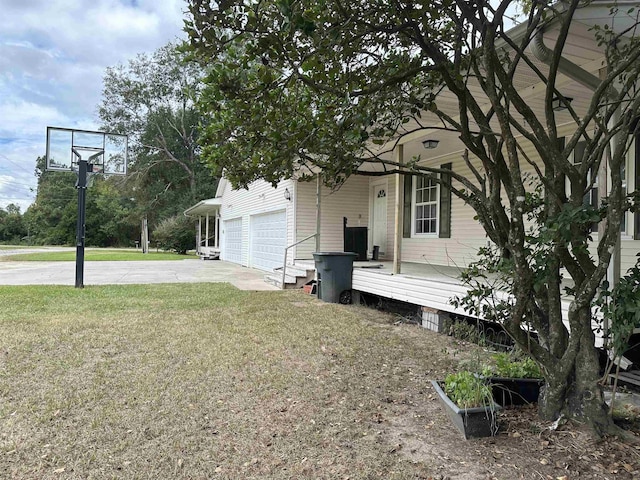 exterior space featuring a lawn, a garage, and covered porch