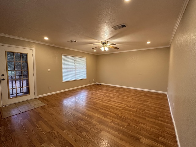 empty room featuring a textured ceiling, hardwood / wood-style flooring, ceiling fan, and ornamental molding