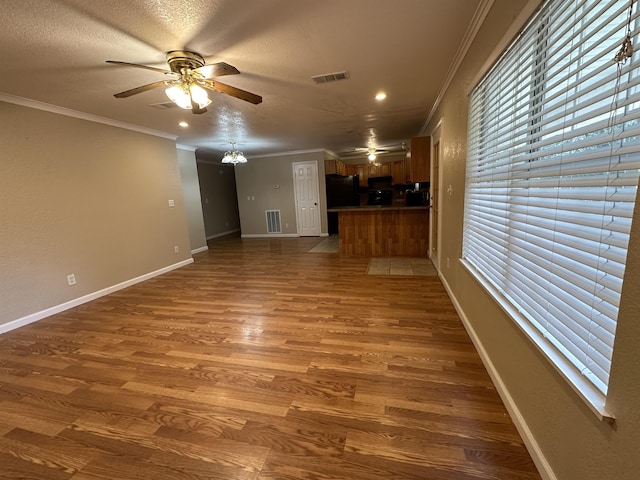 unfurnished living room with ceiling fan, dark hardwood / wood-style flooring, a textured ceiling, and ornamental molding