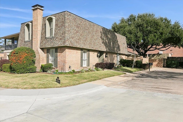 6570 Windwood Ln, Beaumont, TX 77706 - view of front of property with mansard roof, a shingled roof, brick siding, and a chimney