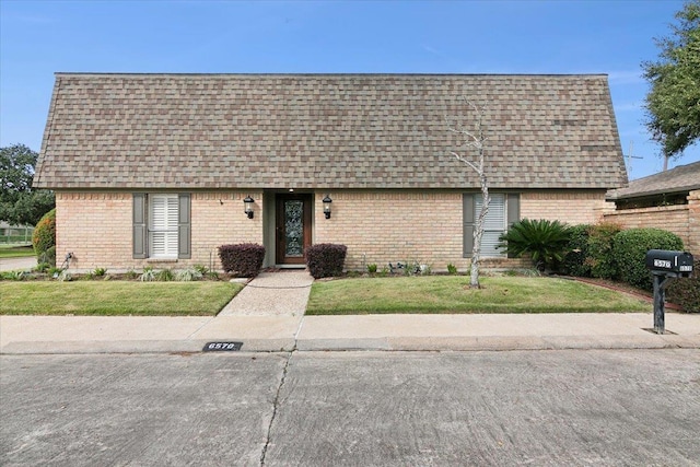 6570 Windwood Ln, Beaumont, TX 77706 - view of front facade featuring roof with shingles, brick siding, and a front lawn