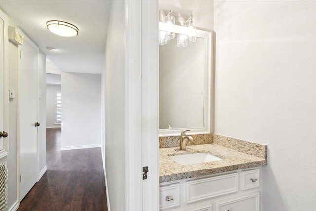 6570 Windwood Ln, Beaumont, TX 77706 - bathroom with vanity, wood finished floors, and baseboards