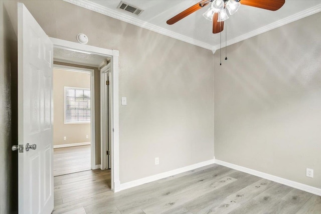 empty room with ceiling fan, light hardwood / wood-style floors, and ornamental molding