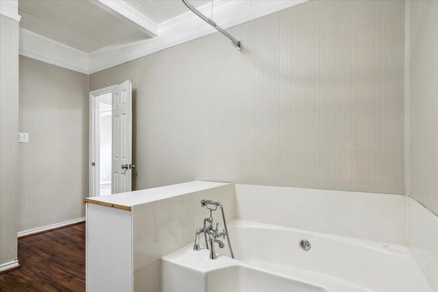 bathroom with a tub to relax in, crown molding, and hardwood / wood-style floors