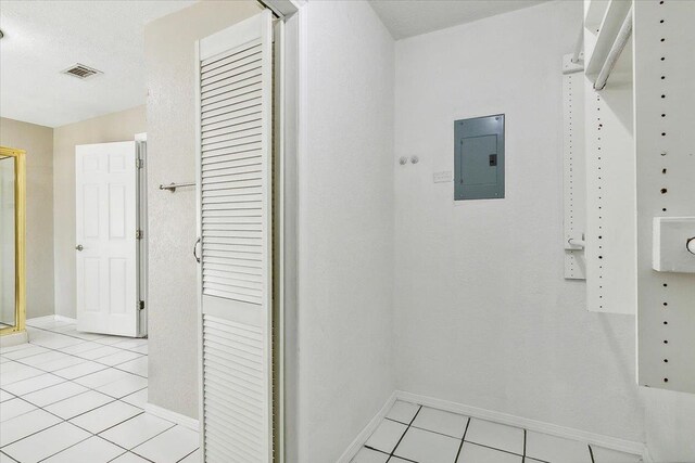 interior space with electric panel and light tile patterned floors