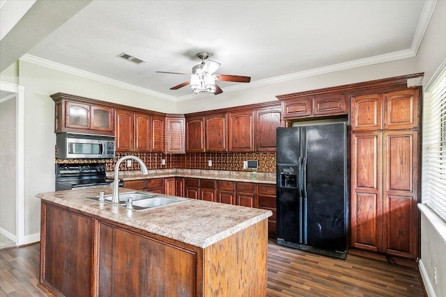 kitchen featuring tasteful backsplash, sink, black appliances, a center island with sink, and dark hardwood / wood-style floors