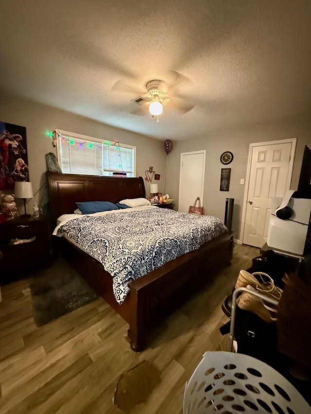 3656 Hemlock St, Orange, TX 77630 - bedroom featuring a textured ceiling, wood finished floors, and a ceiling fan
