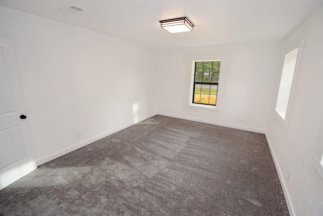 unfurnished room featuring dark carpet