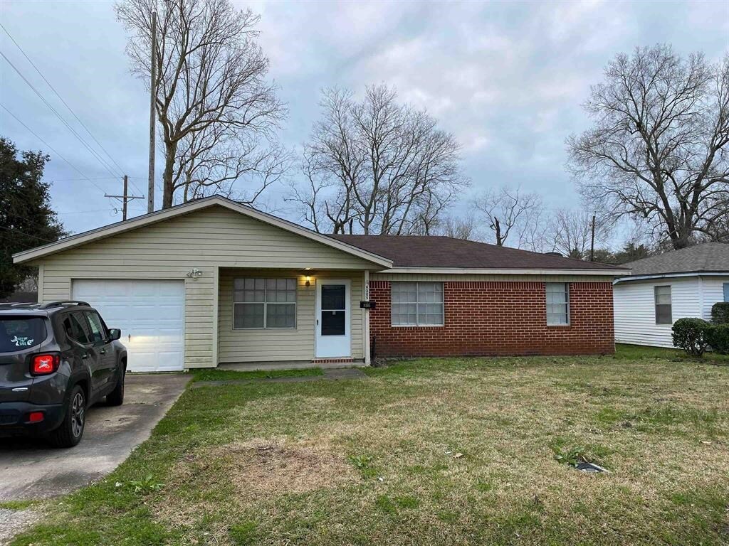9305 Gardner St, Beaumont, TX 77707 - single story home with concrete driveway, an attached garage, a front lawn, and brick siding