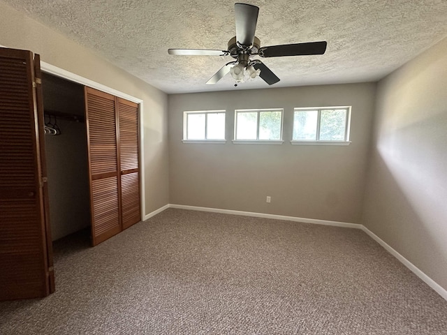 unfurnished bedroom with a ceiling fan, carpet, baseboards, a closet, and a textured ceiling