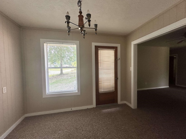 interior space featuring dark colored carpet, baseboards, a textured ceiling, and a chandelier