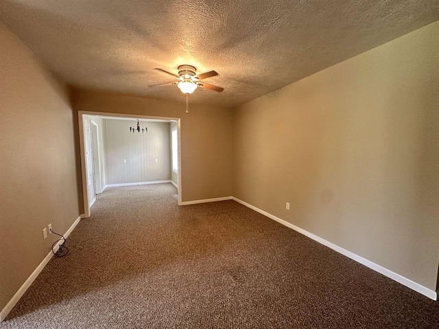 spare room featuring a textured ceiling, baseboards, dark carpet, and ceiling fan