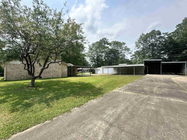 view of yard with a pole building, an outdoor structure, a garage, and driveway