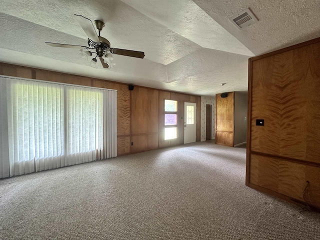 empty room featuring visible vents, a textured ceiling, ceiling fan, and carpet floors