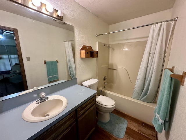 full bathroom with shower / bath combination with curtain, vanity, a textured ceiling, hardwood / wood-style floors, and toilet