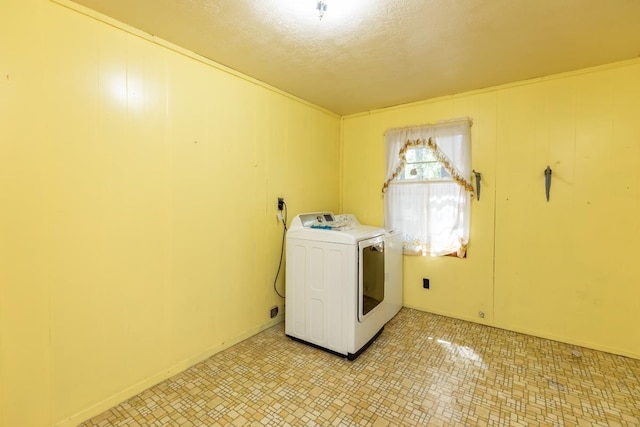 laundry room with a textured ceiling and washer / clothes dryer