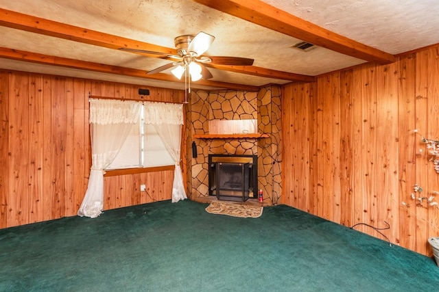 unfurnished living room with beam ceiling, wood walls, and carpet