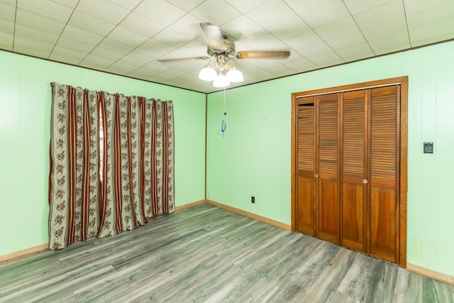 unfurnished bedroom featuring ceiling fan, a closet, and light wood-type flooring