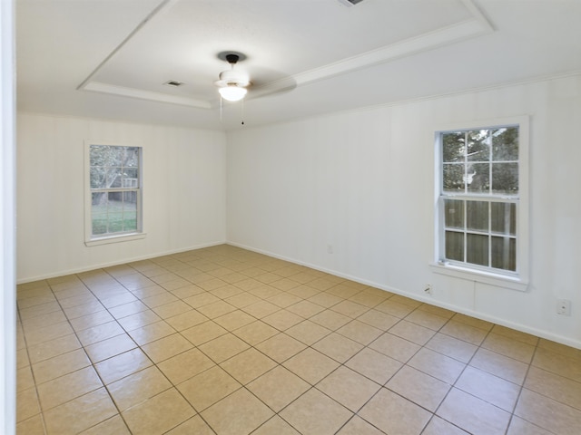 spare room with crown molding, ceiling fan, a raised ceiling, and light tile patterned floors