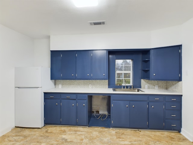 kitchen featuring white refrigerator, sink, and blue cabinets