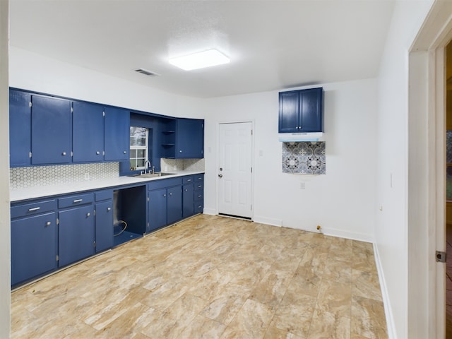 kitchen featuring sink, decorative backsplash, and blue cabinetry