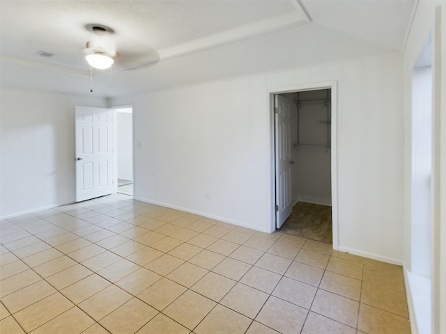 spare room with crown molding, ceiling fan, and light tile patterned floors